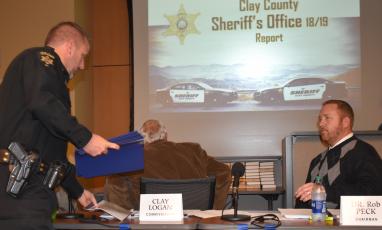 (Becky Long • Clay County Progress) Clay County Sheriff Bobby Deese hands out reports to the commission board including Chairman Rob Peck during a Feb. 6 meeting. Deese provided a statistical update of his first year in office.