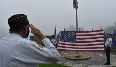 (Becky Long • Clay County Progress) George Lee American Legion 532 Commander Joe Buckner salutes as Dwight McClure and Phil Cantley conduct the folding of the American flag. The Legion hosted a 9/11 memorial service at the Veterans Memorial Park Friday morning.