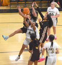Gary Corsair • Clay County Progress Hayesville's Kadence Morrow, No. 4, throws herself into the fray in an attempt to wrestle a rebound away from Cherokee as Lady Yellow Jackets Jasmine Brooks, No. 3, and Ava Moore, No. 40, arrive to help.