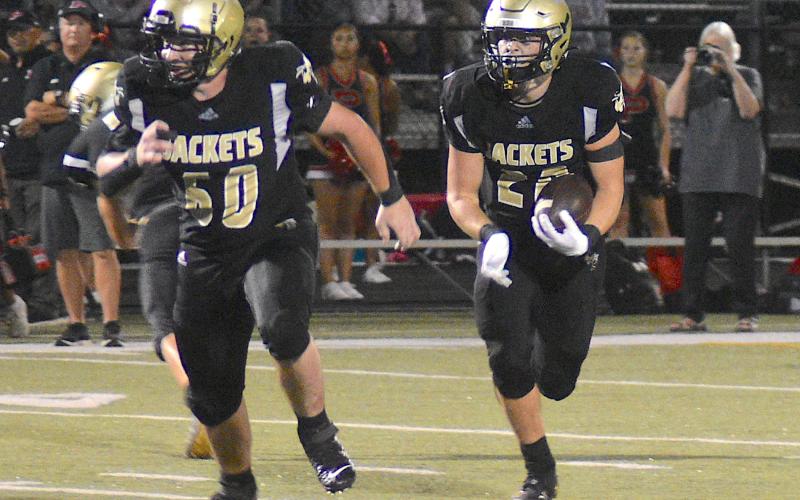 Gary Corsair • Clay County Progress Lane O'Dell, No. 60, leads Taylor McClure, No. 20, on a Hayesville sweep. McClure rushed for a team-high 84 yards and scored the only Yellow Jacket touchdown. He is averaging a whopping 8 yards per carry on the season.